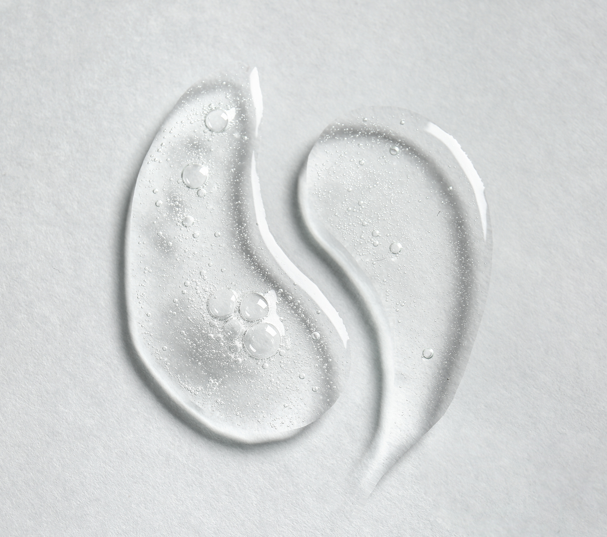 Drops of Cosmetic Serum on Light Background